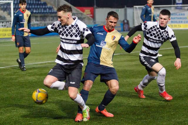 Players battle for possession of the ball in midfield