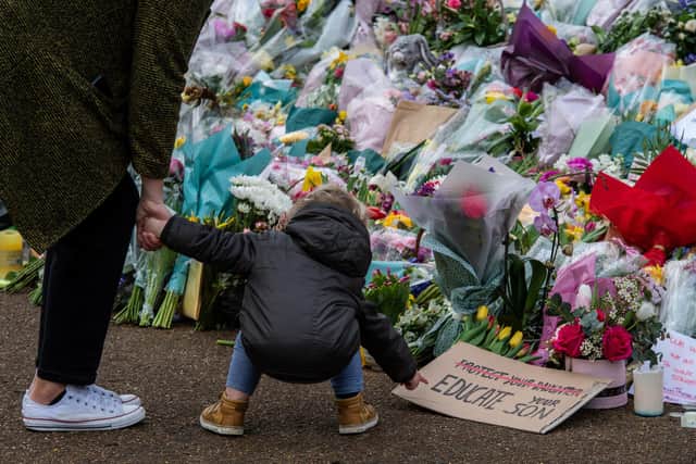 A parent takes their son to look at floral tributes left at Clapham Common bandstand to Sarah Everard  (Photo by Chris J Ratcliffe/Getty Images)