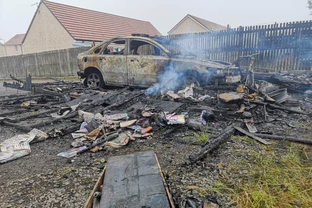 A burned-out car which is thought to belong to an elderly resident whose garage went on fire. Picture: Steven Derry.