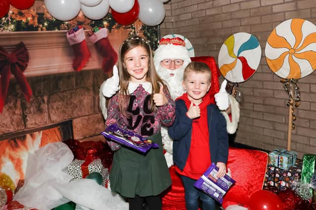 Rosie, 8, and Oliver, 5, from Bo'ness meet Santa at the Winter Wonderland event on Saturday.  Pictures: Scott Louden.