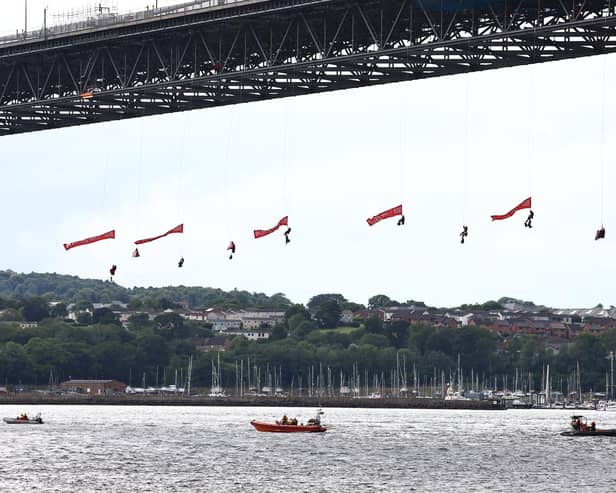 An international team of Greenpeace activists abseil from Scotland's Forth Bridge to block an Ineos tanker from delivering its cargo of fracked American gas to the Grangemouth petrochemical facility. 