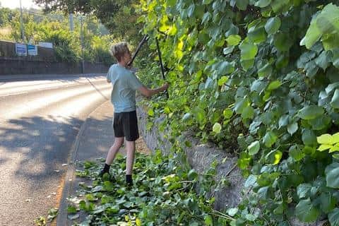 Kai Kallus trims back the bushes which were actually growing out onto the B805 Redding Road