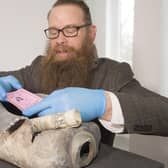 Consultant Conservator Nic Boyes  opens the 1898 time capsule discovered during the move of the Burns statue on Constitution Street, Leith, Edinburgh, for the tram works