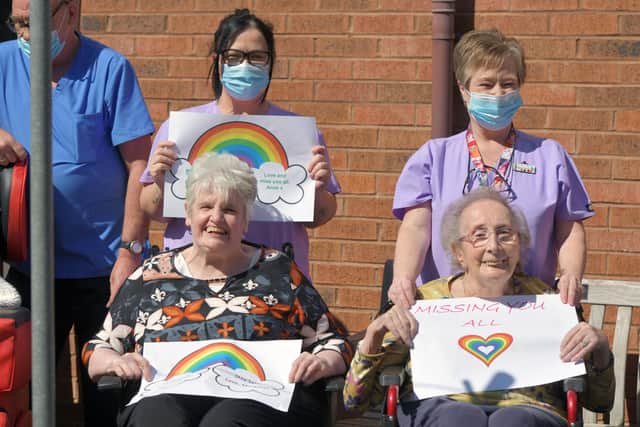 Staff and residents of Carrondale Nursing Home in Carron hold up messages and best wishes to loved ones