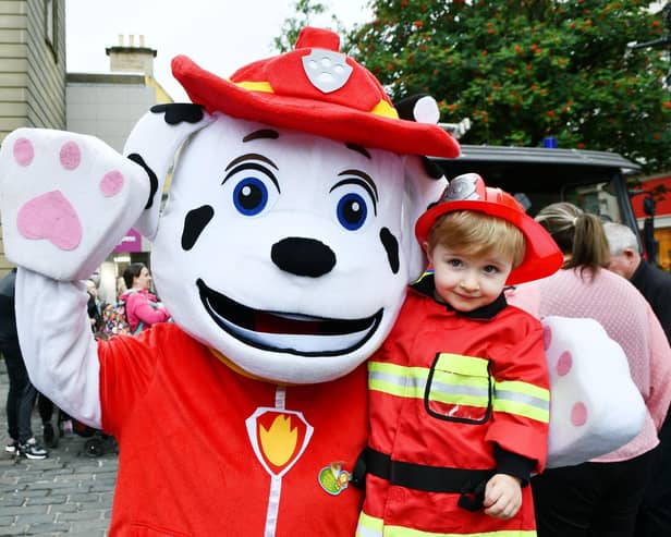 Liam Easson, 2, from Bonnbyridge meets Marshall from PAW Patrol - and they're both wearing their firefighter uniforms.