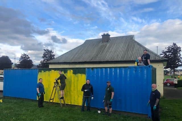 Members of Falkirk Round Table painting the container