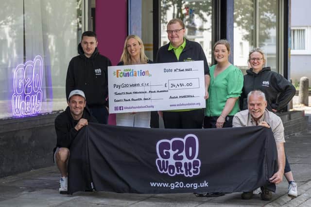 Asda Maryhill Champion Ryan Rooney presenting cheque to G20 Works
