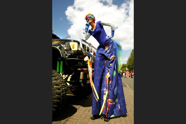 Stilt walker takes a rest at the monster truck.