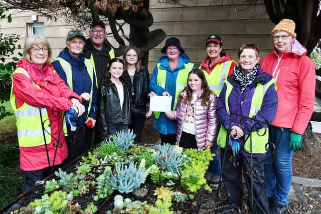 Amelia Hogg, Maya Lewandowska and Victoria Hogg present their cheque to Sheila Rhind and other gLitter team members. Pic: Michael Gillen