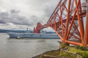 HMS Queen Elizabeth passes under the Forth Bridge as she heads back to sea following lengthy time at Rosyth for repairs and upgrades due to mechanical fault.   (Pic: Katielee Arrowsmith/SWNS)