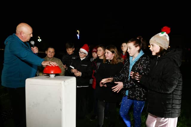 Local resident and singer Dougie Smith switched on the Christmas lights with help from some P7 pupils last year.  The lights are organised by Carronshore Heritage Forum.  Pic: Michael Gillen.