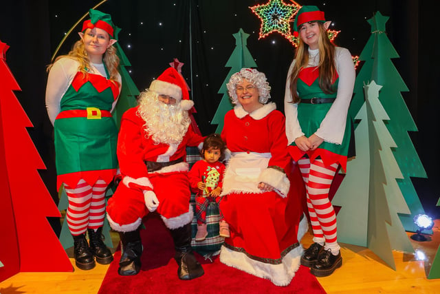 Zoe James, aged 2, meets Santa and his elves Jingle and Elfie.