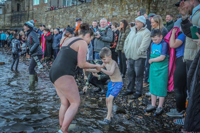All ages braved the icy water and this wee one was getting a helping hand to take his first tentative steps in the dook!