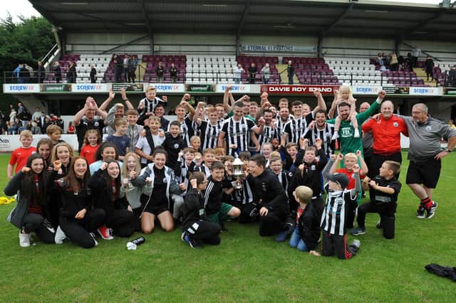 Dunipace players, fans and coaching staff are all smiles after getting their hands on the trophy. Pic by Michael Gillen