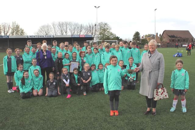 Dr Margot Buchanan presents the McLaren Trophy to young players from Bo’ness United Community Football Club, watched by Madelene Hunt from Bo’ness Community Council,.