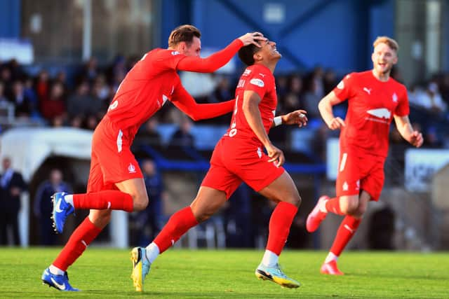 Juan Alegria is mobbed by his teammates after scoring to make it 2-0