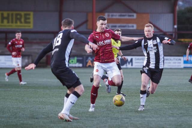 Michael Miller drives forward past the Elgin City midfield