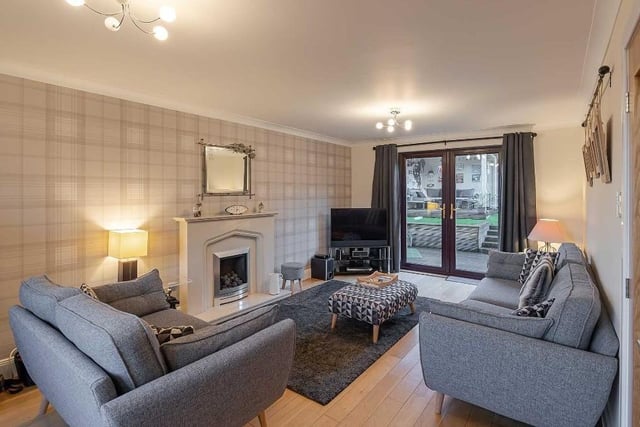 The spacious living room, with its feature gas fireplace, has double doors which lead out into the sun trap garden.