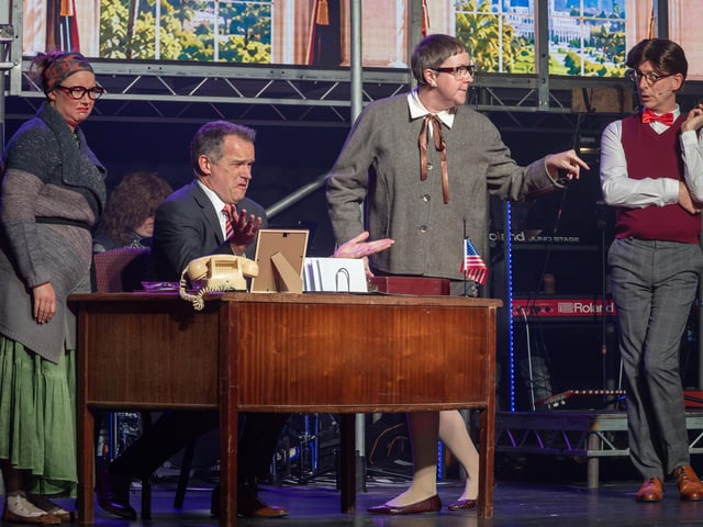 German developer Hertz (Hannah Sanderson) and son Franz (Iain Davidson) meet with Mayor (Colin Fawkes) and Regina (Roslyn Fricker) to discuss the demolition of the Sunset Strip.