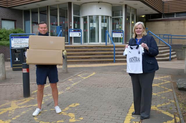 Cecil Meiklejohn accepting a donation of Falkirk FC football strips for kids attending the primary school hubs from Kieran Koszary, Falkirk FC. Picture Michael Gillen.