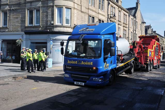 The vehicle involved in the incident is towed away as police officers look on