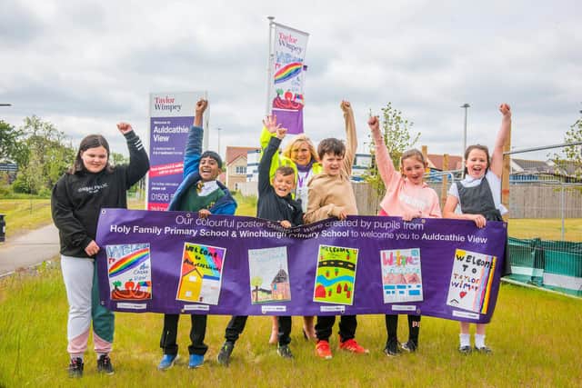 The winner from Holy Family Primary (second from left) with his winning flag design, alongside Taylor Wimpey East Scotland’s sales executive Amanda Baxter and the runners-up from both Holy Family and Winchburgh Primary schools.