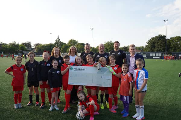 Euan Stainbank alongside Lisa Riley and members of the Dunipace FC girls team. (Pic. Contributed.)