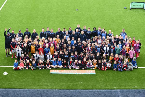 The Junior Bairns' members pose for a group picture on the Falkirk Stadium pitch alongside boss John McGlynn and the first team players who attended