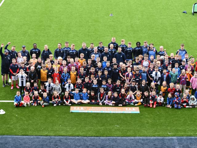 The Junior Bairns' members pose for a group picture on the Falkirk Stadium pitch alongside boss John McGlynn and the first team players who attended