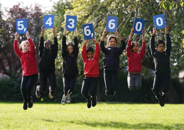 Pupils from Stenhouse Primary School, Edinburgh holding up cards showing the new estimate of the population during the launch of the first results from Scotland's Census 2022