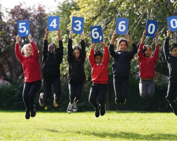 Pupils from Stenhouse Primary School, Edinburgh holding up cards showing the new estimate of the population during the launch of the first results from Scotland's Census 2022