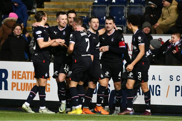 Captain Stephen McGinn is mobbed by his teammates after scoring the second goal