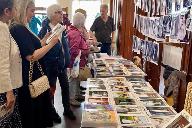People browsing the selection of old Fair programmes and videos/dvds that were for sale.