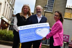 Falkirk Delivers chair Deborah Taylor, front, signs the Scotland Loves Local Pledge with fellow BID directors Linton Smith and Lisa Fowler. (Pic: Scotland’s Towns Partnership)