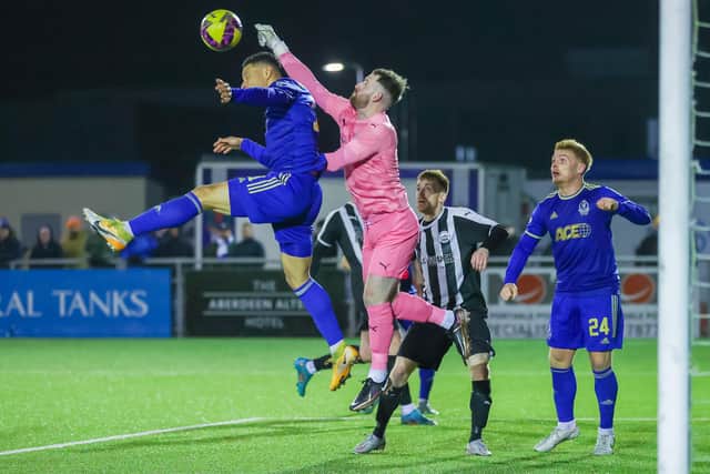 David Kane punches clear with Leighton McIntosh in close attention