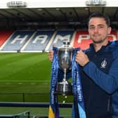 Falkirk captain Stephen McGinn holds aloft the SPFL Trust Trophy at a pre-round press conference held at Hampden Park in Glasgow (Photo: Mark Runnacles/Electrify)