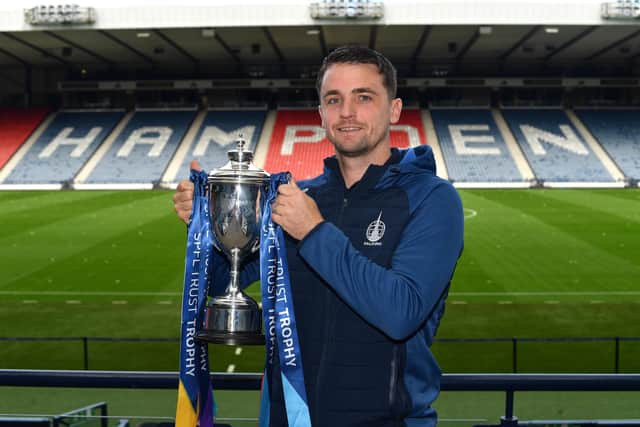 Falkirk captain Stephen McGinn holds aloft the SPFL Trust Trophy at a pre-round press conference held at Hampden Park in Glasgow (Photo: Mark Runnacles/Electrify)