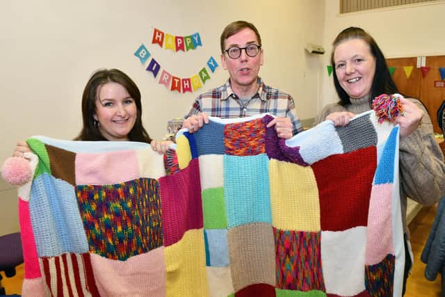 Amy Lord, Creative Fieldworker The People’s Parish Bainsford and Langlees; David Henderson, Community Development Lead Strathcarron Hospice and Angela Smith, Corra Foundation Community Co-ordinator (Bainsford and Langlees) with the blanket created by those attending the craft cafe which has been donated to Strathcarron Hospice.  (Pic: Michael Gillen)