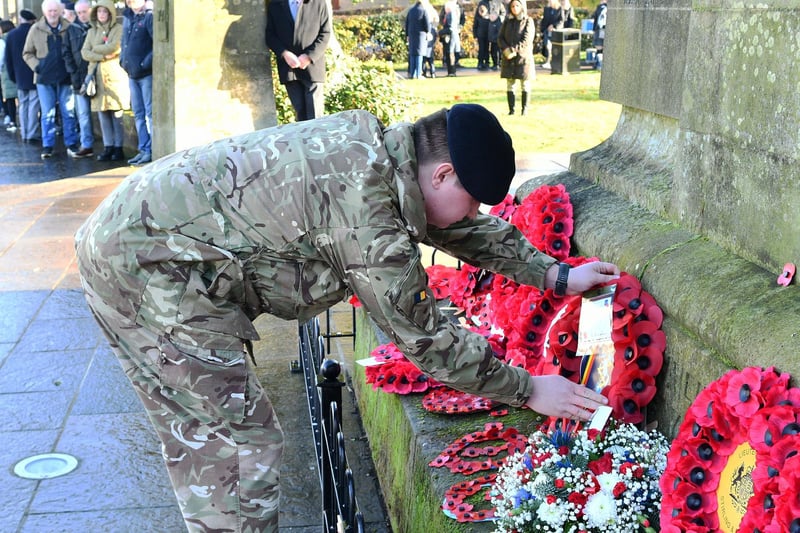 Carefully placing a wreath amongst the many tributes.