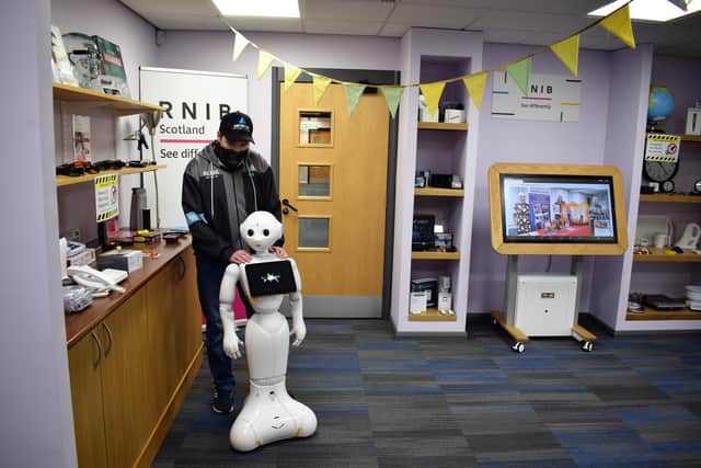 Kyle Somerville, 20, from Falkirk with robot guide Pepper