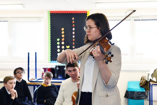 The pupils listen to violinist Annabel Kidd.