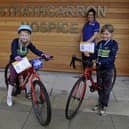 Strathcarron Hospice ward sister Susan Bateman thanks Falkirk Junior Bike Club members Carly Scott, 7, and Freya McQueen, 8, for the group's fundraising efforts on behalf of the Fankerton service. Picture: Michael Gillen.