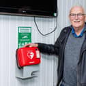 Steve Jelfs who saved a man's life at Bowhouse Community Centre with his CPR skills pictured with centre's defibrillator. Pic: Mark Ferguson