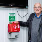 Steve Jelfs who saved a man's life at Bowhouse Community Centre with his CPR skills pictured with centre's defibrillator. Pic: Mark Ferguson