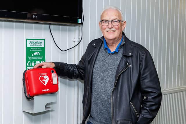 Steve Jelfs who saved a man's life at Bowhouse Community Centre with his CPR skills pictured with centre's defibrillator. Pic: Mark Ferguson