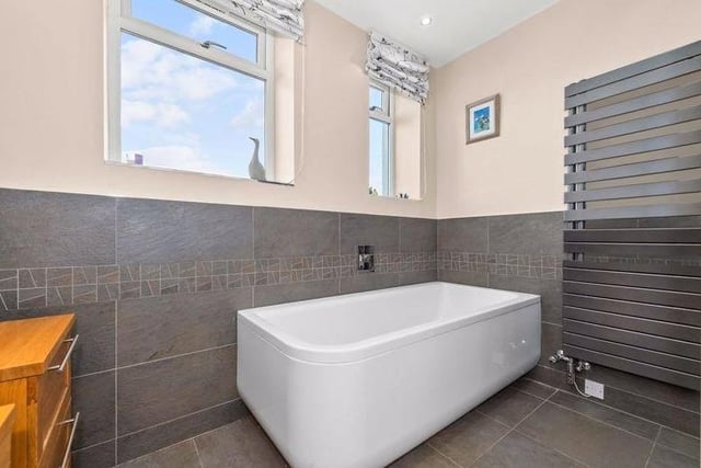 Stylish bathroom has a beautiful tub so you can soak away all those aches and pains.