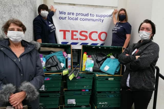 Tesco support for families in Westquarter, Falkirk, who were flooded out in August - residents Joanne Ure and Pat Parsons collecting the items from Tesco Community Champions Angela Combe and Arlene Campbell.