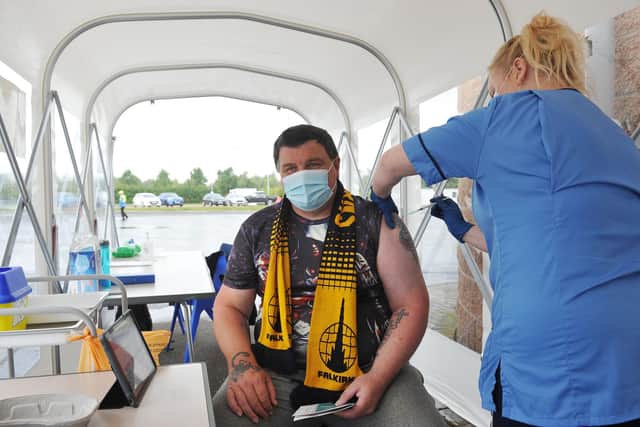 Falkirk fan Collin Reid, 46, from Grangemouth, receives his second Covid vaccine from staff nurse Heather Dowell in the pop-up tunnel at The Falkirk Stadium. Picture: Michael Gillen.