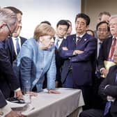 In one of the least diplomatic photos ever,  German Chancellor Angela Merkel speaks with U.S. President Donald Trump, seated at right, during the G7 Leaders Summit in La Malbaie, Quebec, Canada, on Saturday, June 9, 2018.  Trump left the summit early and refused to endorse the official statement - calling Canadian Prime Minister Justin Trudeau "very dishonest and weak"