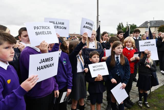 Schoolchildren hold aloft the names of the 40 miners who died in 1923. Pic: Michael Gillen
